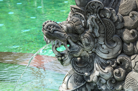 God statue with the pond of ancient temple in Bali, Indonesia.の写真素材