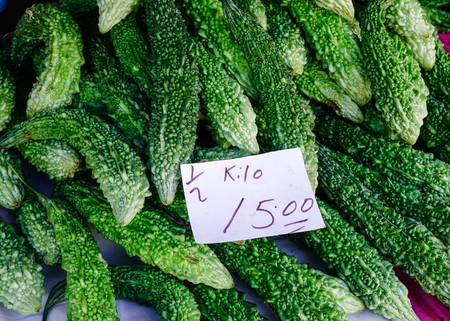 Fresh green bitter gourd or bitter melon herb at rural market