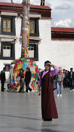 Tibet, China - Sep 7, 2012. A Tibetan woman standing in front of Jokhang Temple in Lhasa, Tibet. The Jokhang Temple has two Buddha statues sacred to Tibetan Buddhists.のeditorial素材