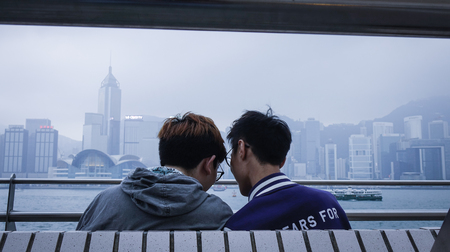 Hong Kong - Mar 29, 2017. An Asian gay couple on embankment of Victoria Harbor in Hong Kong. In 2014...