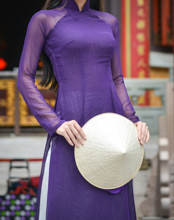 Asian woman in Vietnamese traditional dress (called Ao Dai) standing at Chinese temple.の写真素材