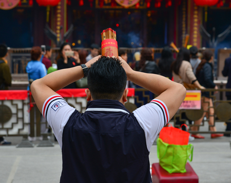 Hong Kong - Mar 30, 2017. A man praying at Wong Tai Sin Temple in Hong Kong, China. Wong Tai Sin or Huang Daxian is a Chinese Taoist deity popular in Hong Kong.のeditorial素材