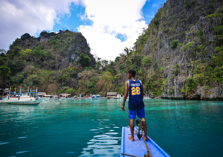 Coron, Philippines - Apr 9, 2017. A man standing on boat in Coron Island, Philippines. Coron is a beautiful island with trees, mangroves, white sand beach and a reef.のeditorial素材