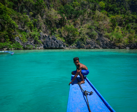 Coron, Philippines - Apr 9, 2017. A man sitting on wooden boat in Coron Island, Philippines. Coron is known for several Japanese shipwrecks of World War II vintage.のeditorial素材