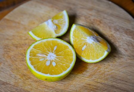 Orange fruit on wooden chopping-board at kitchen. Close up.の写真素材