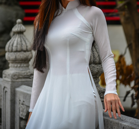 An Asian woman in Vietnamese traditional dress (called Ao Dai) at Chinese pagoda in Hong Kong.の写真素材