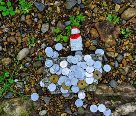 Wakayama, Japan - Nov 24, 2016. Small Buddha with praying coins on Mt. Koya in Wakayama, Japan. Mount Koya (Koya-san in Japanese) is one of Japan most sacred mountains.のeditorial素材