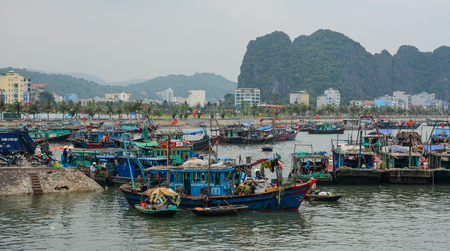 Quang Ninh, Vietnam - May 23, 2016. Fishing boats docking on Ha Long Bay in Quang Ninh, Vietnam. Ha Long Bay is a UNESCO Site and popular travel destination.