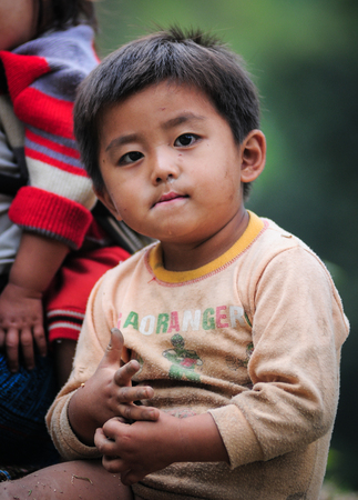 Ha Giang, Vietnam - Sep 19, 2013. A boy sitting on rural road in Ha Giang, Vietnam. Many people in Ha Giang belong to one of Vietnam ethnic minorities.のeditorial素材