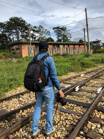 Dalat, Vietnam - Dec 3, 2017. A photographer with backpack walking on old rail tracks in Dalat, Vietnam. Da Lat was developed as a resort by the French in the early 1900s.のeditorial素材