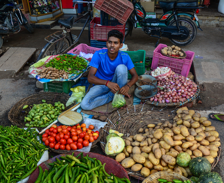 Varanasi, India - Jul 12, 2015. A man selling vegetables at street market in Varanasi, India. Varanasi is the holiest of the seven sacred cities (Sapta Puri) in Buddhism, Hinduism and Jainism.のeditorial素材
