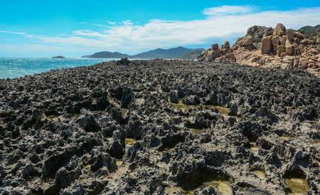 Black rocks at sunny day in Nha Trang Bay, South Central Coast of Vietnam.の写真素材