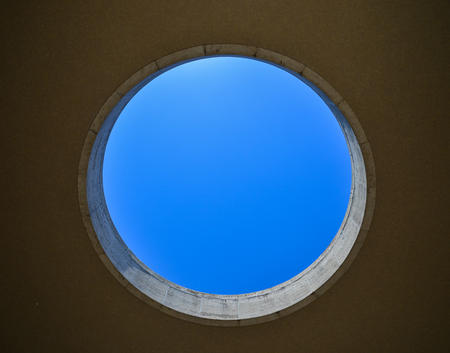 Blue sky can be seen throw a hole of modern building.の写真素材