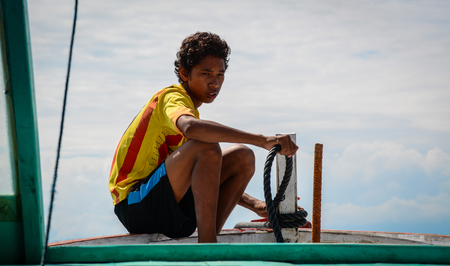 Lombok, Indonesia - Apr 19, 2016. A boy sitting on wooden boat in Lombok, Indonesia. Lombok, an island next to Bali where the tourism is still in its infancy.のeditorial素材