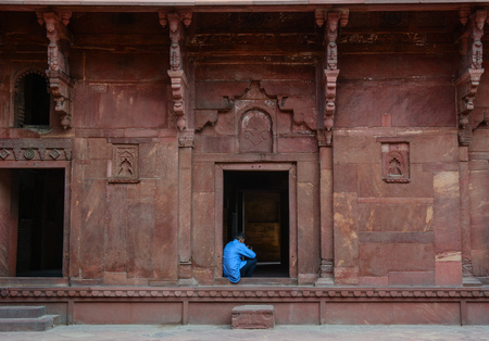 Agra, India - Jul 13, 2015. An Indian man sitting at Agra Fort in Agra, India. The fort was main residence of the emperors of the Mughal Dynasty till 1638.のeditorial素材