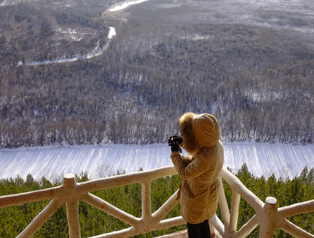 A woman standing and looking at winter scenery in North of China.の写真素材