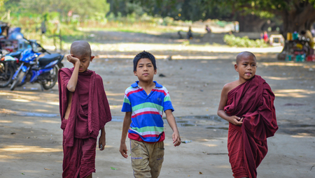 Bagan, Myanmar - Feb 11, 2017. Young novice monks walking on rural road in Bagan, Myanmar. Bagan in central Burma is one of the world greatest archeological sites.のeditorial素材