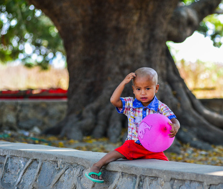 Mandalay, Myanmar - Feb 11, 2017. A little boy playing with a balloon at the park in Mandalay, Myanmar.のeditorial素材