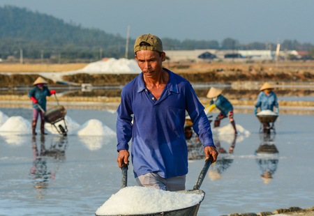 Khanh Hoa, Vietnam - Mar 21, 2016. A man working on the salt field at Ninh Hoa Town in Khanh Hoa, Vietnam.のeditorial素材