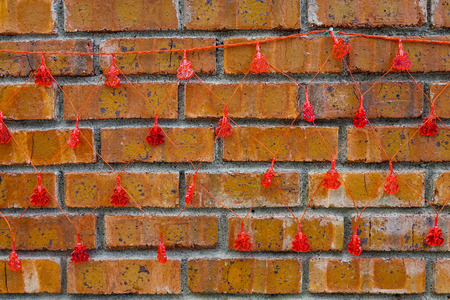 Old brick wall at ancient village with hanging lucky decorations.の写真素材