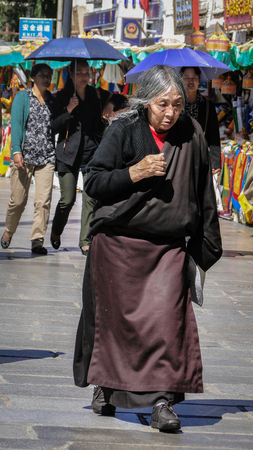 Tibet, China - Aug 30, 2012. People walking on square in Lhasa, Tibet, China. Tibet is a historical region covering much of the Tibetan Plateau in Central Asia.のeditorial素材