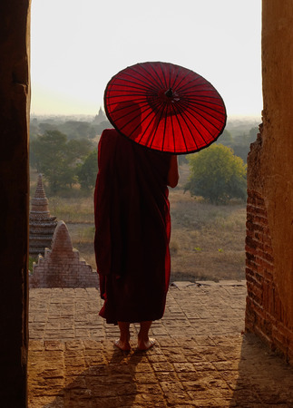 A young monk coming to ancient Buddhist temple in Bagan, Myanmar.の写真素材