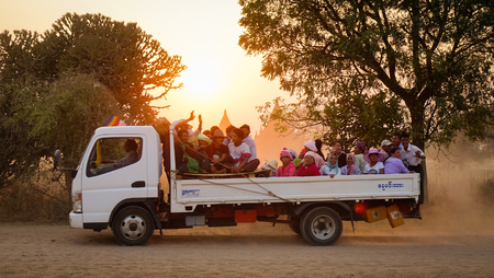 Bagan, Myanmar - Feb 19, 2016. A car carrying local people on dusty road at sunset in Bagan, Myanmar.のeditorial素材