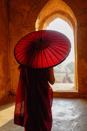 A young monk standing at Buddhist pagoda in Bagan, Myanmar.の写真素材