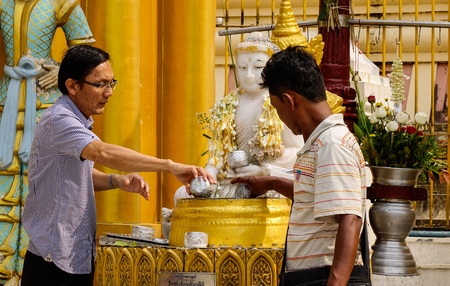 Yangon, Myanmar - Feb 26, 2016. Burmese men praying at Shwedagon Pagoda in Yangon, Myanmar. Shwedagon is known as the most sacred pagoda in Myanmar.のeditorial素材