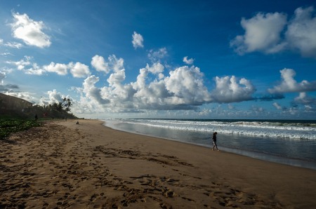 Hikkaduwa, Sri Lanka - Sep 9, 2015. A woman walking on sand beach at sunrise in Hikkaduwa, Sri Lanka.のeditorial素材
