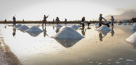Nha Trang, Vietnam - Mar 21, 2016. People working on salt field in Nha Trang, Vietnam. Salt fields is one of the most unique destinations in Nha Trang.の写真素材