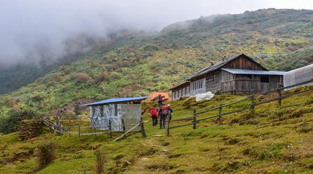 Trekkers with backpack coming to teahouse on trail of Annapurna Circuit Trekking in Khopra, Nepal.
