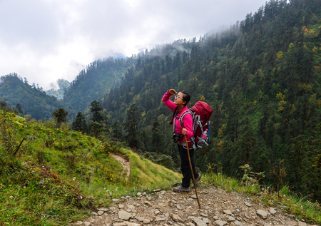 Khopra, Nepal - Oct 22, 2017. Young woman with backpack walking on trail of Annapurna Circuit Trekking in Khopra, Nepal.のeditorial素材