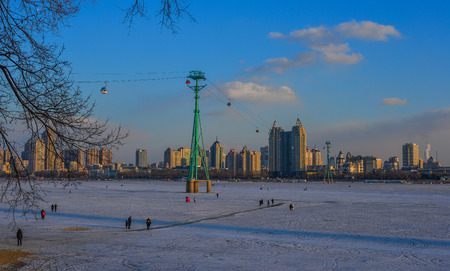 Harbin, China - Feb 22, 2018. Cityscape with ice river at sunset in Harbin, China. Harbin is largest...