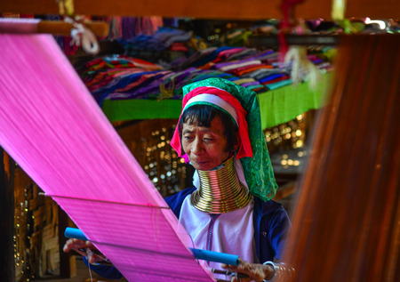Inle Lake, Myanmar - Feb 7, 2018. A Kayan woman (Long Neck People) weaving silk fabric on a wooden loom in Inle Lake, Myanmar.のeditorial素材