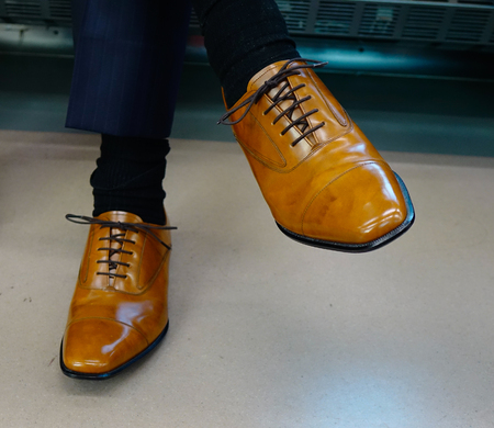 Man wearing vintage leather shoes. Clothes and accessories background.