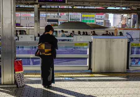 Nagoya, Japan - Dec 3, 2016. A woman in kimono at railway station in Nagoya, Japan. Trains are a very convenient way for visitors to travel around Japan.のeditorial素材
