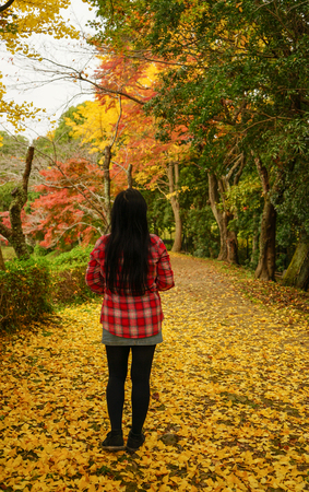 A young woman enjoying at autumn park in Kyoto, Japan.のeditorial素材