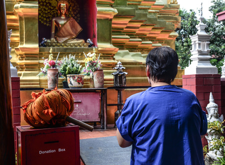 A woman praying at Buddhist temple in Chiang Mai, Thailand.のeditorial素材