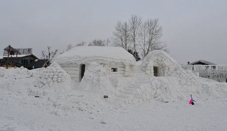 Traditional snow house with red lanterns at mountain village in Northernmost China.の写真素材