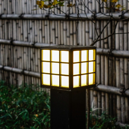 Japanese wooden lamp at garden with bamboo fence in twilight.の写真素材