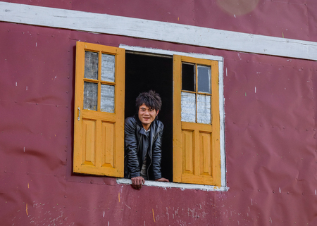 Inle, Myanmar - Feb 15, 2016. A man standing at thÆ° window of wooden house on Inle Lake, Myanmar.のeditorial素材