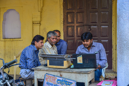 Jaipur, India - Nov 3, 2017. Local men with typewriters on street in Jaipur, India. Auto rickshaws are used in cities and towns for short distances.のeditorial素材
