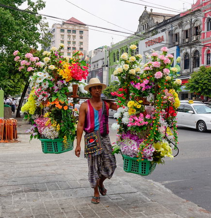 Yangon, Myanmar - Feb 26, 2016. A man selling fake flowers on street in Yangon, Myanmar. Yangon is Myanmar largest city and its most important commercial centre.のeditorial素材