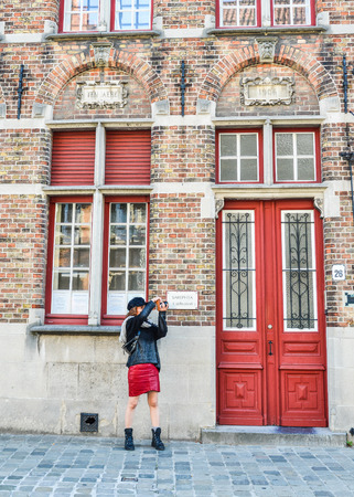 Bruges, Belgium - Oct 5, 2018. A woman standing on street at Historical Centre of Bruges (Brugge), Belgium.のeditorial素材