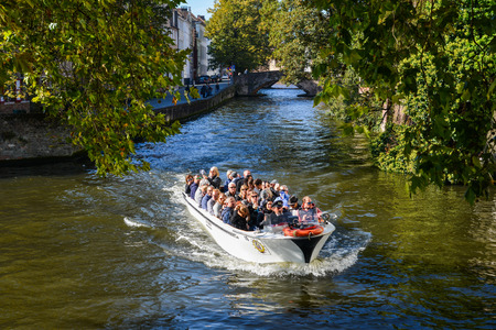 Bruges, Belgium - Oct 5, 2018. Tourist boat running on the main canal in Bruges (Brugge), Belgium.のeditorial素材