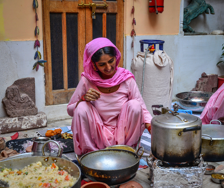 Jodhpur, India - Nov 6, 2017. Women cooking Indian traditional meal in Jodhpur, India. Jodhpur is...