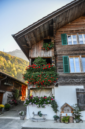 Old wooden house with flower decorations at mountain village near the Lake Brienz, Switzerland.のeditorial素材