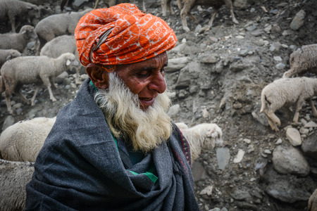 Srinagar, India - Jul 2, 2015. Portrait of shepherd with sheep on mountain in Srinagar, India.
