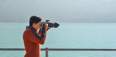 Brienz, Switzerland - Oct 21, 2018. A young photographer taking pictures near the Lake Brienz. Brienz  is a lake just north of the Alps, in the canton of Berne.のeditorial素材